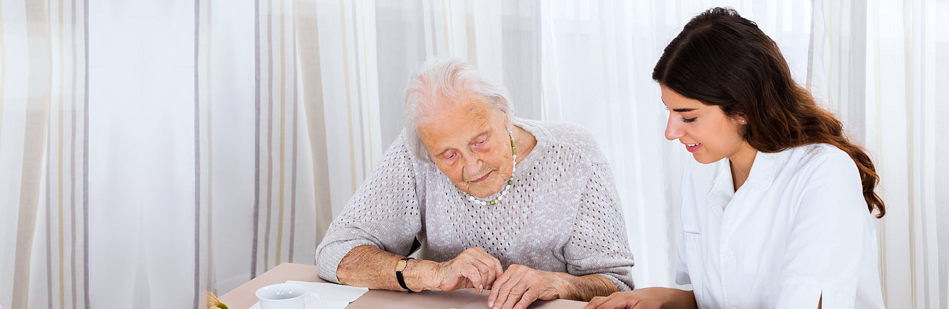caregiver assiting senior to read