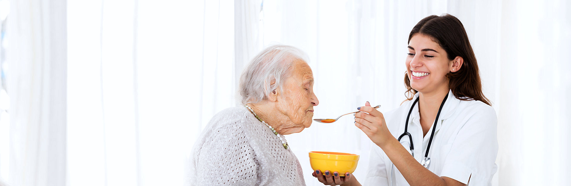 caregiver feeding a senior