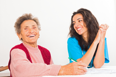 senior woman with her caregiver laughing
